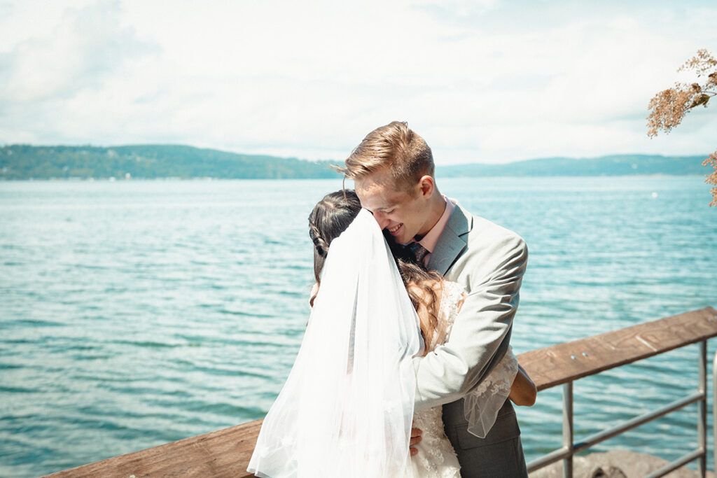 bride and groom hugging by the sea by Kiriell Visuals