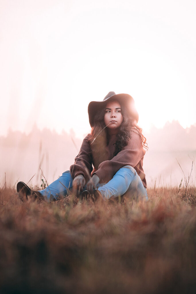 young woman sitting on grass by Kiriell Visuals